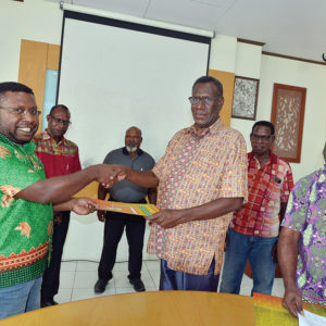 Direktur LEMASA, Odizeus Beanal (kiri) menerima berkas perjanjian kerja sama dari Ketua BAdan Pengurus LPMAK, Robertus Waropea.