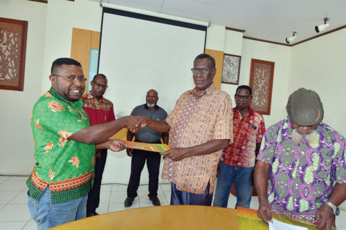 Direktur LEMASA, Odizeus Beanal (kiri) menerima berkas perjanjian kerja sama dari Ketua BAdan Pengurus LPMAK, Robertus Waropea.