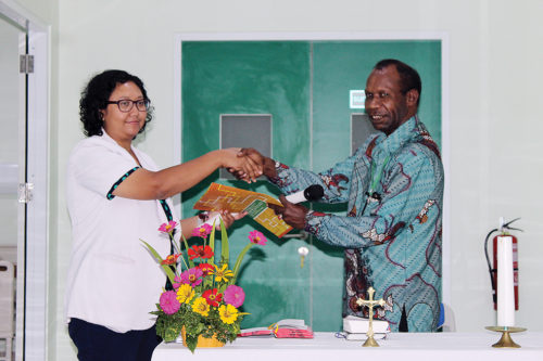 Sekretaris Eksekutif LPMAK, Abraham Timang menyerahkan berkas serah terima Bangsal Santa Clara kepada Plt. Direktur RSMM, dr. Theresia Nina di Timika, Senin (15/4). (Etty Wellerubun/LPMAK)