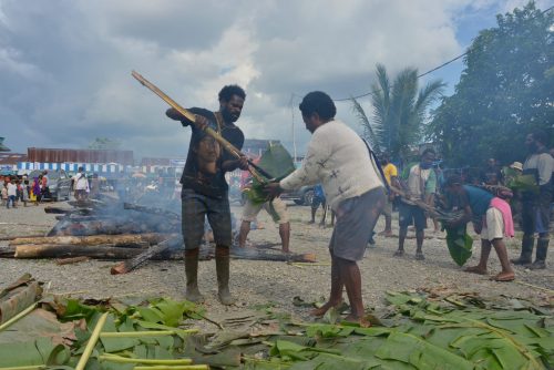 Membungkus batu panas dengan daun pisang