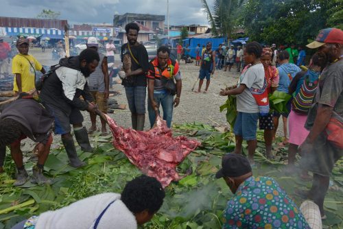 Setelah keladi ditutup dengan batu panas yang telah dibungkus daun pisang, sayur diletakan diatasnya kemudian daging babi diletakan diatas sayur.